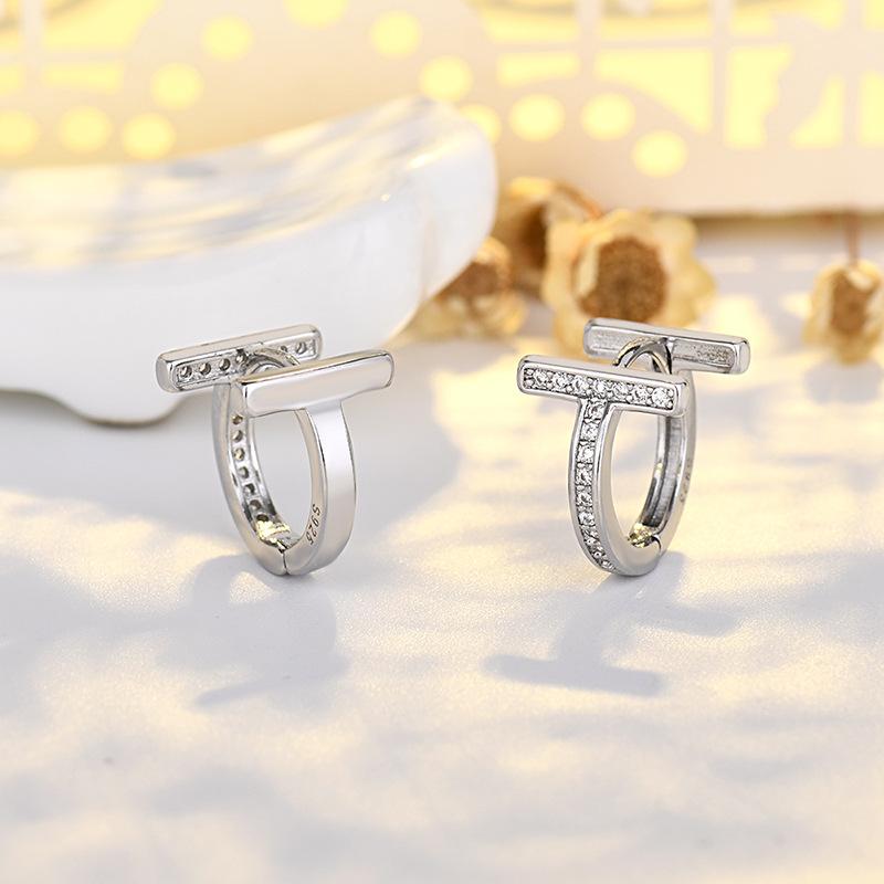 Modne kolczyki sztyfty z podwójnym T i pełnym diamentem, złote, luksusowe, z literą wykonaną techniką czystego igłowania