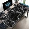 A Large Electronic Sports Gaming Mouse Pad Featuring an Abstract Design with Flowing Black And White Lines
