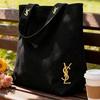 תיק כתף קנבס שחור של YSL, בעיצוב מינימליסטי במיוחד עם קיבולת גדולה, מתאים לעבודה, לקניות, ללימודים ולנסיעות.