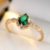 A ring inlaid with egg-shaped green synthetic zirconia, featuring a lace design, is elegant, simple, classic, exquisite, fashionable, luxurious, and