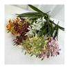 Realistische Seiden-Dendrobium-Orchidee mit Blättern für Blumengesteck auf dem Esstisch