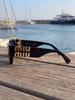 MIU MIU Óculos de Sol SMU09W - Armação Gatinho Preta com Logo Dourado