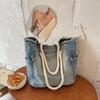Geräumige Tragetasche aus bequemem, lässigem Denim-Stoff, geeignet zum Pendeln über einer Schulter.