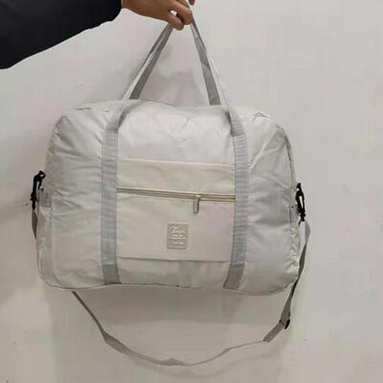 Compact travel bag: suitcase-compatible, hand-held, features an external pocket, handle slip-over design, with matching accessory bag.