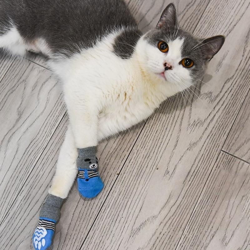 Four-pack of autumn/winter cartoon anti-slip socks for pets, including cat and dog warm socks with paw prints, perfect as a holiday gift.