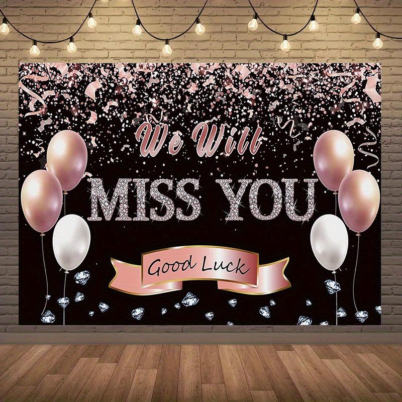 A photo backdrop for a retirement farewell celebration featuring a rose gold banner that reads "We will miss you"