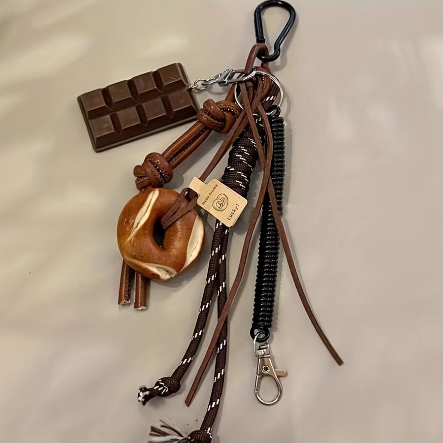

A Punk-Style Themed Faux Leather Keychain Featuring a Resin Chocolate And a Lye Bagel Pendant, Adding a Creative And Fashionable Decorative