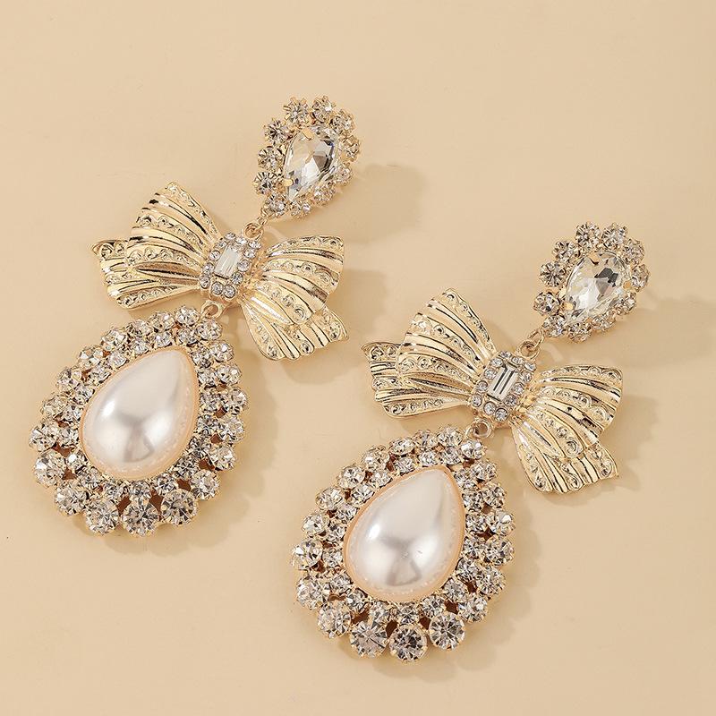 

Light Luxury Bowknot Earrings: Diamond-Studded Faux Pearl Teardrop with Silver Needle for Women.