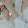Super delicate, soft-toned orange, pink, and purple natural freshwater pearl bracelet with a small, bead-like design, elastic, and minimalist style