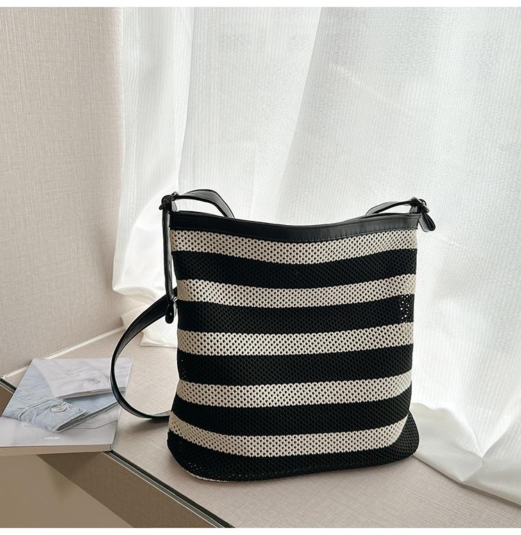 

Striped woven bag women s 2025 new seaside super fire hollow tote bag large capacity fashion commuter messenger bag