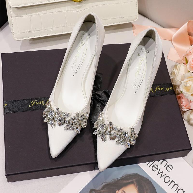 Vita högklackade bröllopsskor i satin med spetsig tå, huvudklänningsvisning, han och hon bär strassknut, förlovning högklackat