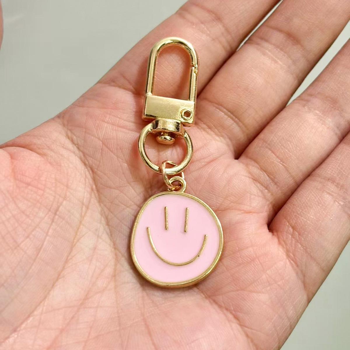 Брелок-подвеска в виде красочной капли масла с изображением смайлика. розовый