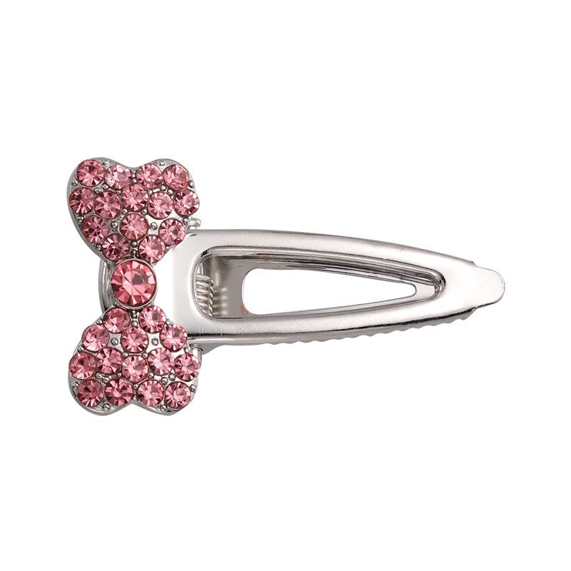 Funky Vibe. Rosa herzförmiger seitlicher Pony mit süßen, coolen, mädchenhaften Metallspangen