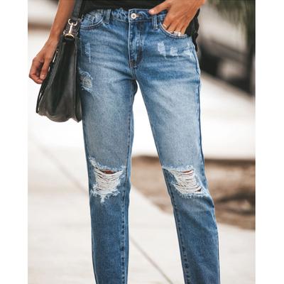 Europäische und amerikanische Damenjeans mit zerrissenen Löchern und Quasten zeigen ihre Dünnheit. Damen Jeans mit langen Hosen