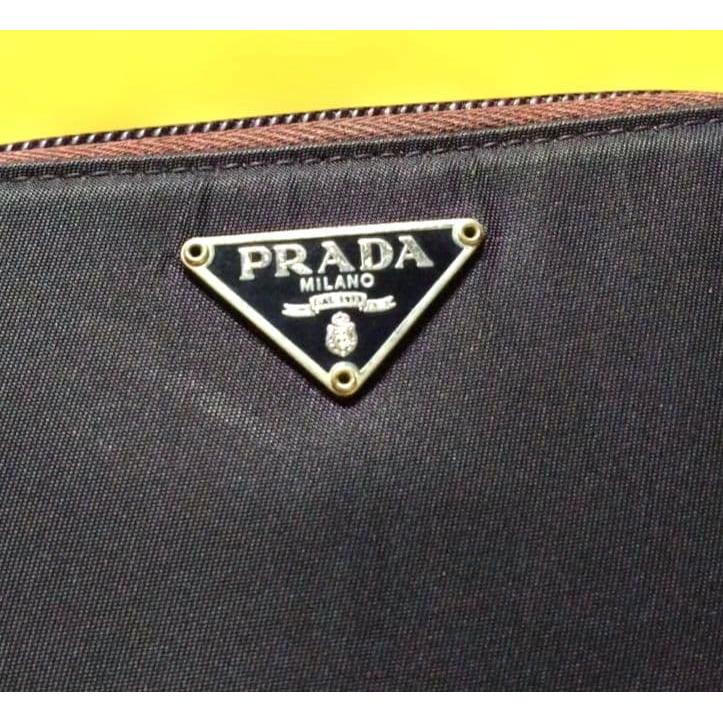 Used Excellent condition PRADA dry plum color bi-fold wallet with triangle logo plate and zipper
