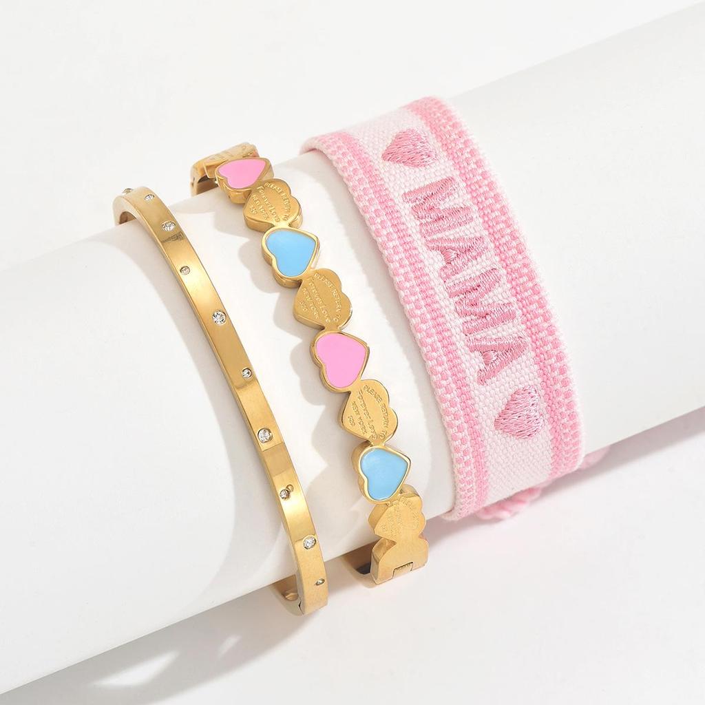 Gold Heart-Shaped Stainless Steel Bracelet with Embroidered Bow and Tassel Woven Cord.