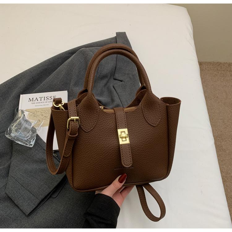 

2025 spring simple temperament light luxury lychee pattern portable bucket bag niche design versatile commuter messenger bag темно-коричневого