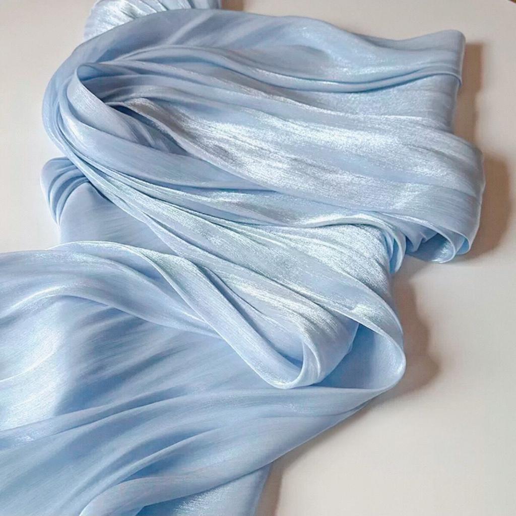 Soft shiny creased organza fabric with a smooth texture suitable for wedding dresses formal gowns and designer clothing fabrics