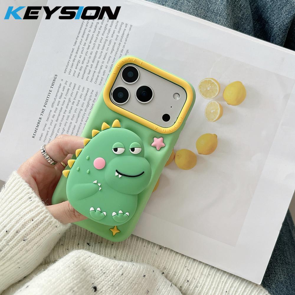 KEYSION Uroczy Kreskówkowy 3D Zabawny Dinozaur Etui na Telefon dla iPhone 13 14 15 16 17 Pro Max Miękki Silikon Podpórka Odporny na Wstrząsy Pokrowiec