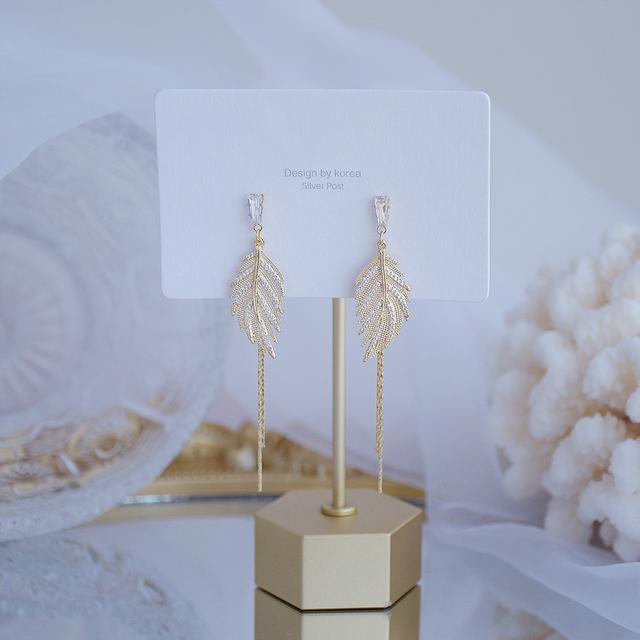 

Изысканные длинные серьги в форме листа с покрытием из настоящего золота 14 карат и инкрустацией из циркония в виде медных листьев. Элегантные и милые женские серьги в корейском стиле. белый