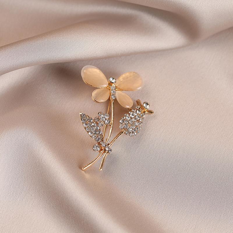 Eine blumige Brosche von leichtem Luxus mit einer hochwertigen femininen Note, eine Nischenanstecknadel, ein raffinierter Anzugmantel und eine exquisite Korsage