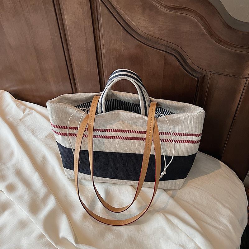 

Niche high-end handbag women s 2025 new striped canvas bag large-capacity shoulder underarm commuter bag