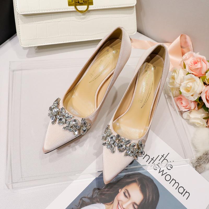 Vita högklackade bröllopsskor i satin med spetsig tå, huvudklänningsvisning, han och hon bär strassknut, förlovning högklackat