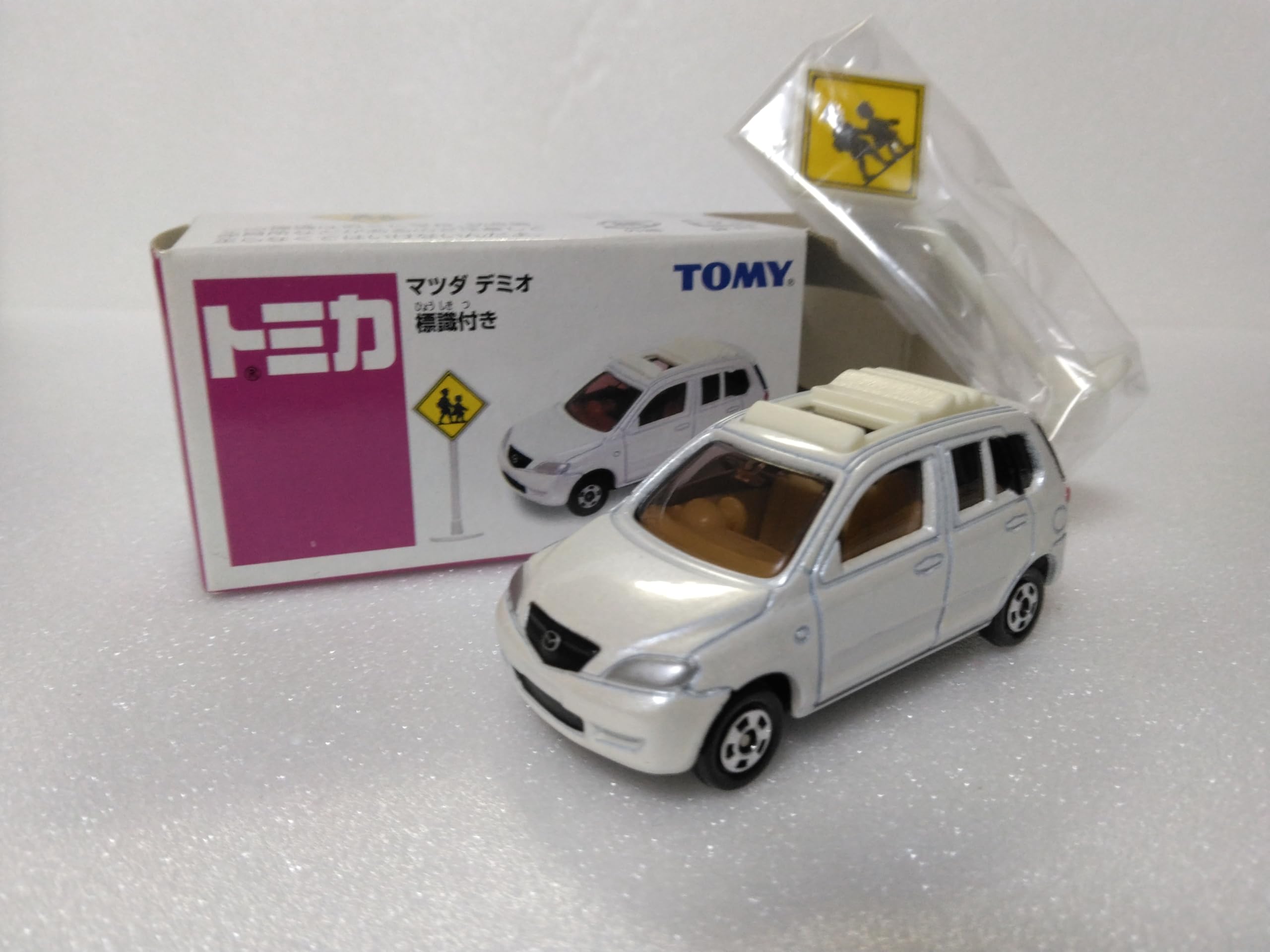 

Литая миниатюрная машинка Tomica Mazda Demio, со знаком, прозрачный кейс