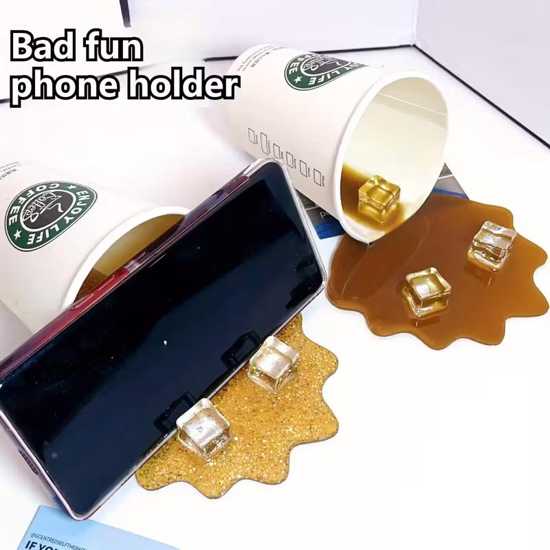 1Pc Overturned Coffee Cup Prank Phone Stand, Plastic Prank Toy, A Must-Have For Lazy People, Home Decoration Ornament.
