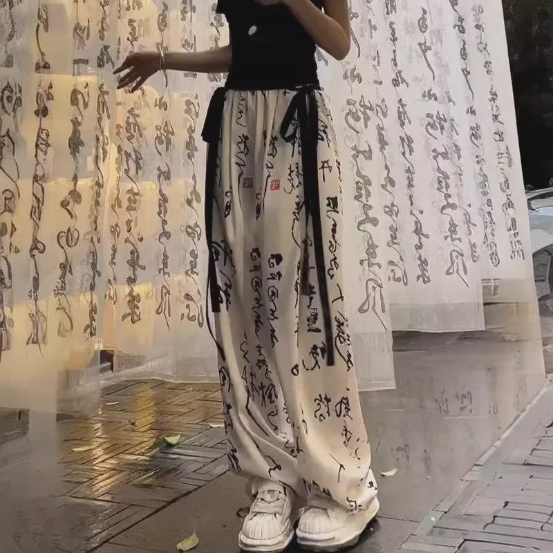 Elegantní kalhoty se širokými nohavicemi z ledového hedvábí s čínskou kaligrafií - Dámské letní ležérní splývavé