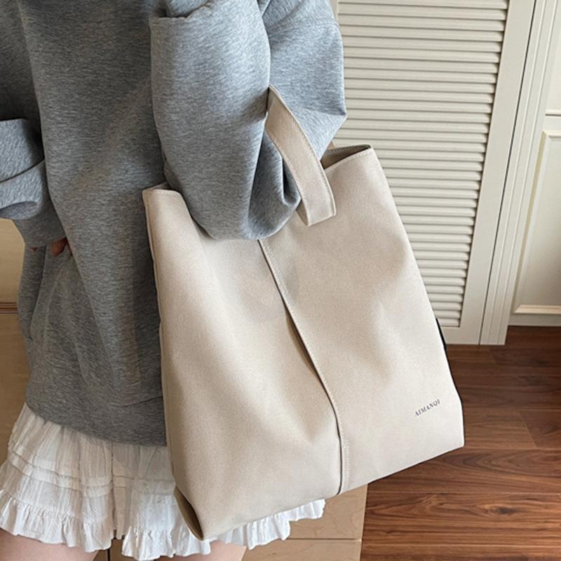 Eine modische und schlichte Umhängetasche aus Stoff mit großem Fassungsvermögen für Pendler-Studenten