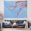 Pink cherry blossoms bloom on an indoor wall decoration tapestry against a blue sky background