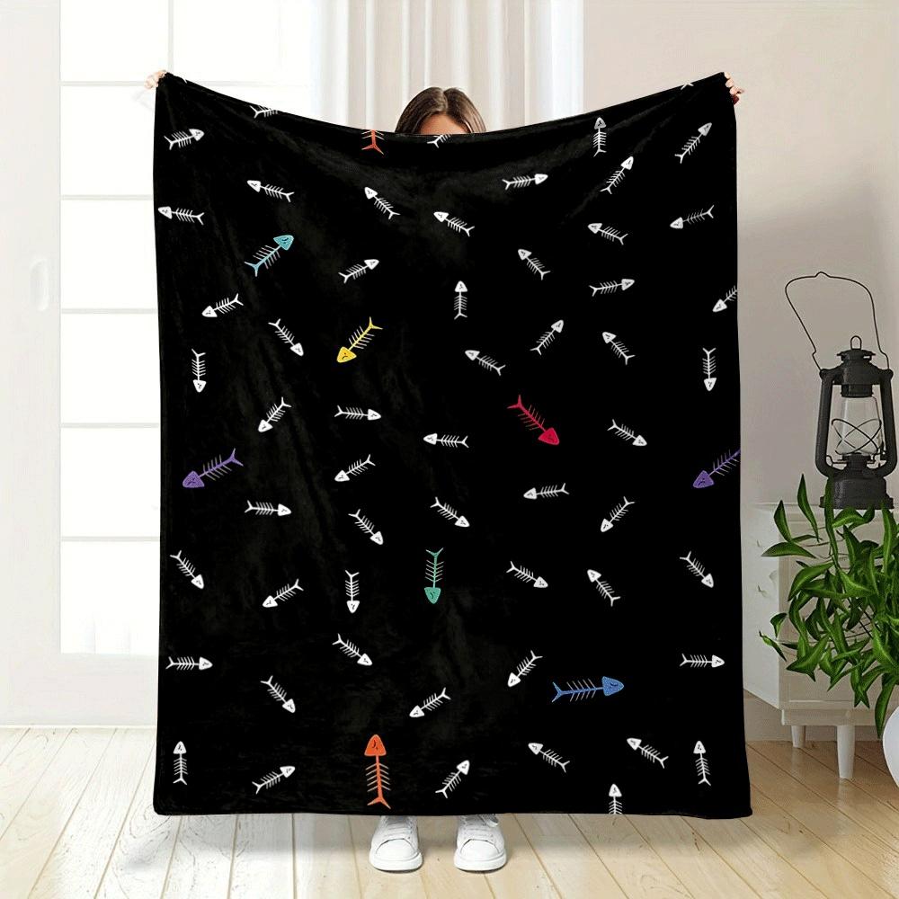 Fish bone patterns with scattered colorful accents on a black background. for all seasons blanket lunch break throw gift