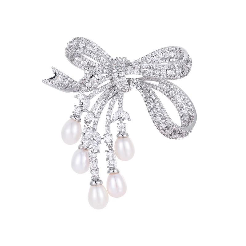 Broșă cu ciucure în formă de fundă cu perle, cu un simț al designului feminin, o broșă nișată și un palton de costum la modă