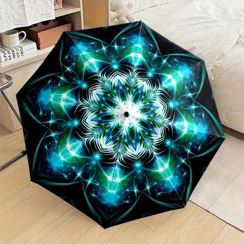 Folding Umbrella The umbrella features a symmetrical mandala pattern with vibrant blue and green starburst designs. Fits Trave