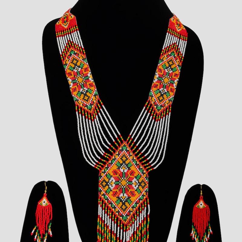 

Ручний довгий намистний браслет з білих та червоних бісерних намистин у богемному стилі з сережками-бахромою