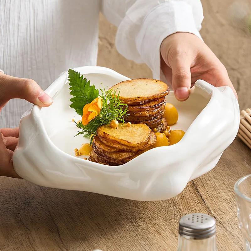 Artistic conception dishes are arranged irregularly. The hotel restaurant features domestic ceramic tableware for cold dishes.