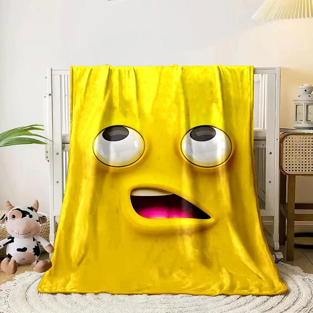 Bright yellow cartoon face with large eyes and an open mouth showing pink. for all seasons blanket lunch break throw gift