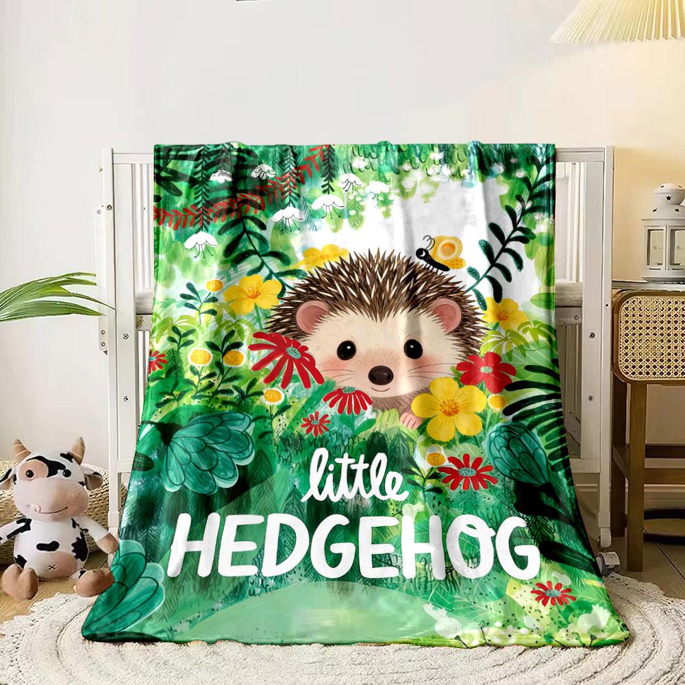 

A cute hedgehog surrounded by vibrant flowers and lush greenery. for all seasons blanket lunch break throw gift 80cm x 120cm