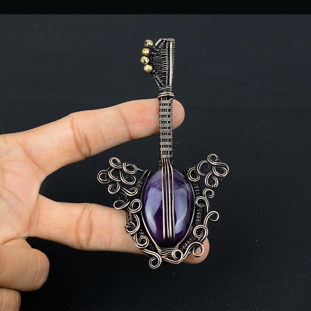 Gitarrenförmiger Amethyst-Edelstein mit Kupferdraht umwickelt, handgefertigter Schmuckanhänger als Geschenk