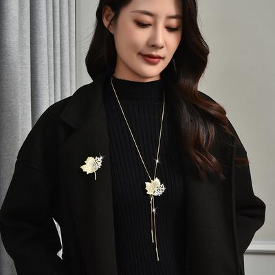 Ein Paar lange Halsketten, Ahornblattpullover, Broschen, Damenmäntel, Oberbekleidungsaccessoires