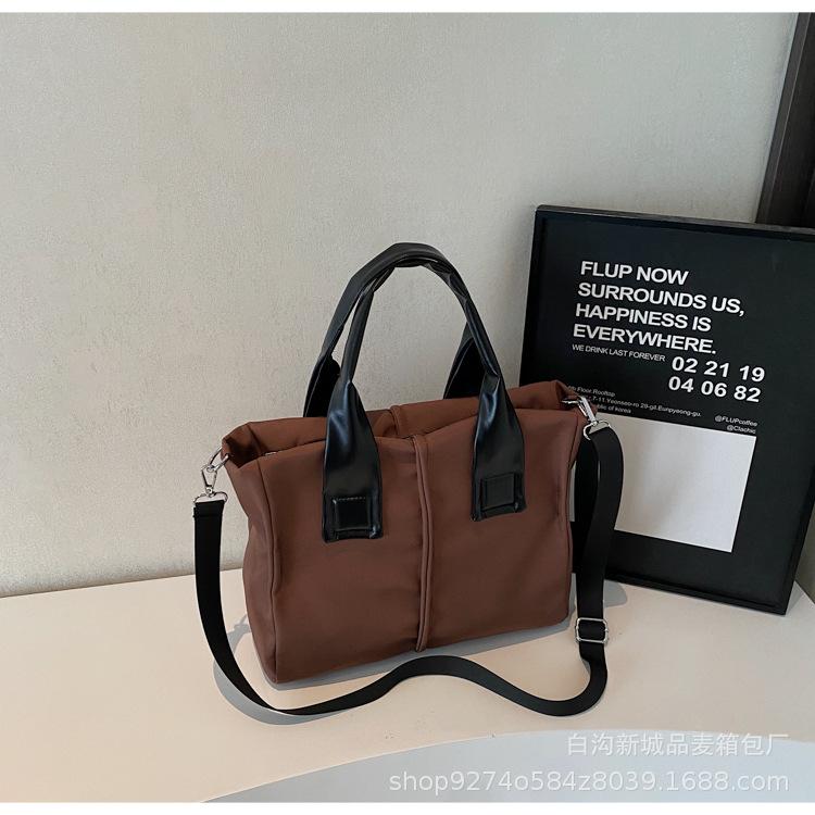 

Japanese fashion solid color large capacity canvas large casual design sense niche shoulder crossbody portable class bag темно-коричневого кольору
