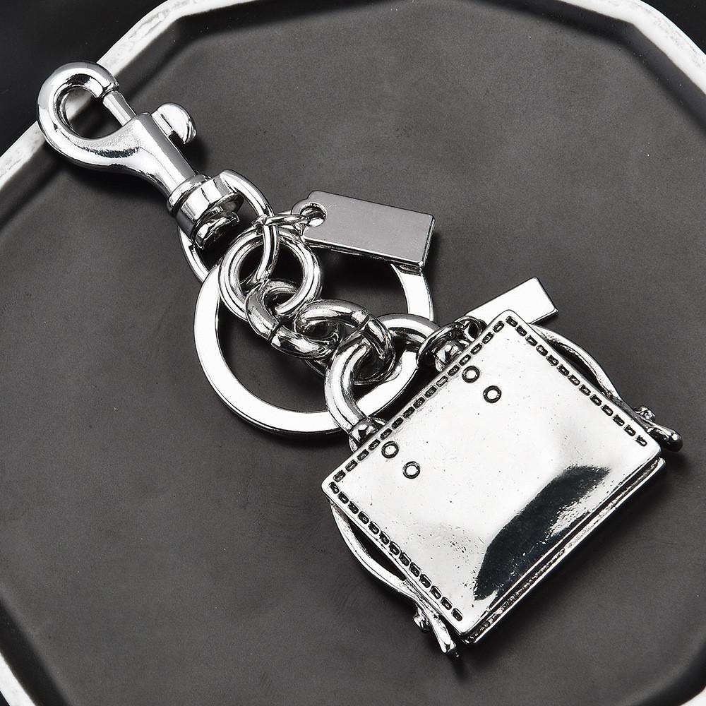 Metallischer Schlüsselanhänger Taschenanhänger Mit Graviertem Buchmuster Für Modeaccessoires