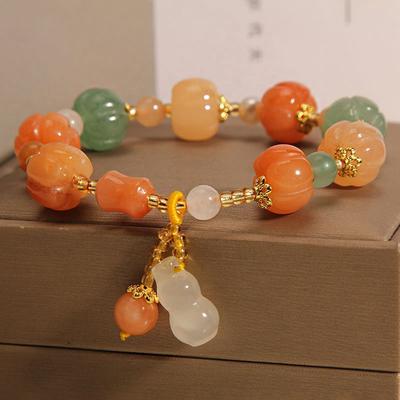 Un bracelet classique chinois en perles de citrouille en soie dorée et jade, un bijou unisexe avec pendentif en forme de gourde d'été
