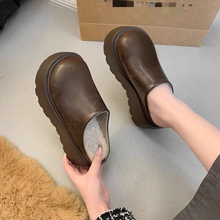 Persoana mică mărește înălțimea capului genții și a papucilor jumătate, și poartă noii papuci Birkenstocks termici din catifea cu talpă groasă toamna.