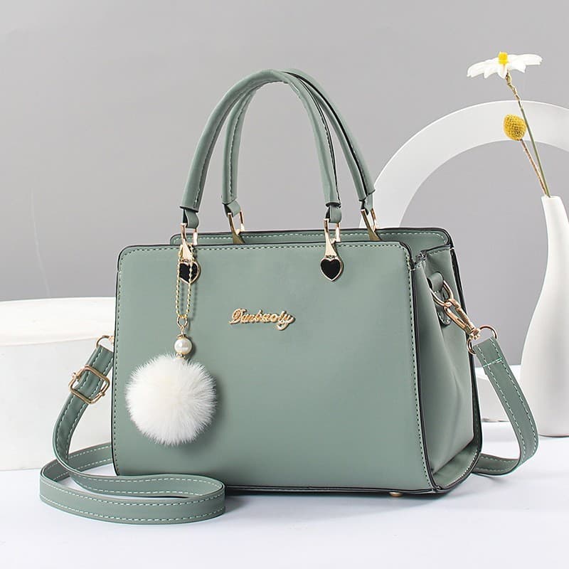 Bolsa pequena transversal decorada com bola de pelo, elegante