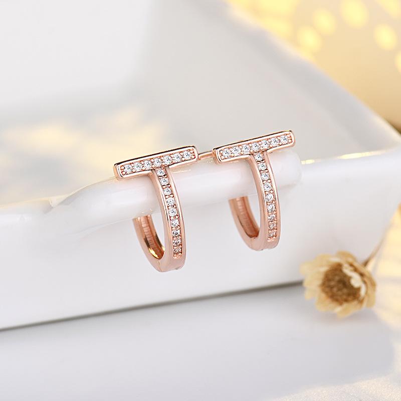 Modne kolczyki sztyfty z podwójnym T i pełnym diamentem, złote, luksusowe, z literą wykonaną techniką czystego igłowania