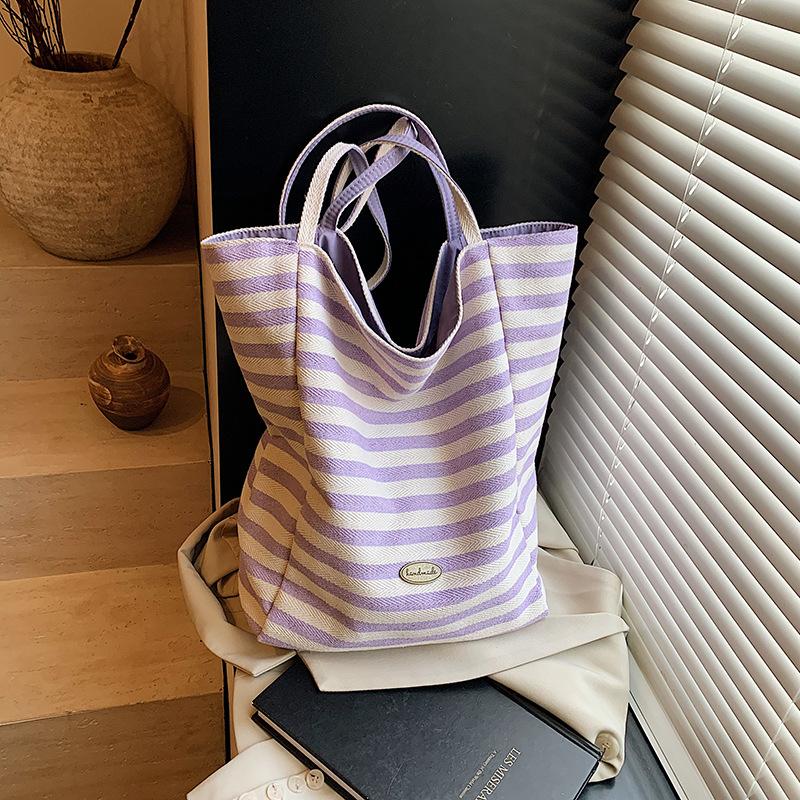 

Korean version of casual lazy style large-capacity underarm bag women s 2025 new double-sided back canvas bag striped bucket bag фіолетовий