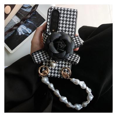 Luxuriöse Leder-Kamelien-Hahnentritt-Handyhülle für Samsung Galaxy Z Fold 4 3 2 5g mit tragbarem, elegantem Perlenarmband