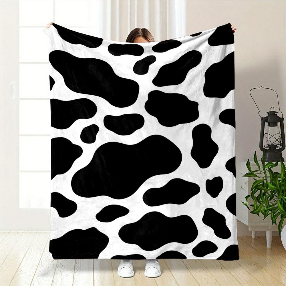 Black irregular spots on a white background resembling a cow print. for all seasons blanket lunch break throw gift